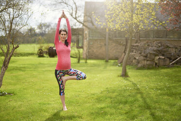 Schwangere Frau im Freien, in Yoga-Position - CUF19716
