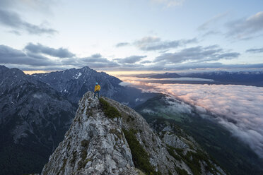Österreich, Tirol, Gnadenwald, Hundskopf, männlicher Bergsteiger im Morgenlicht am Fels stehend - CVF00631