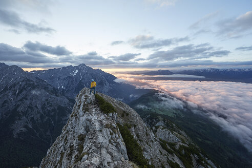 Austria, Tyrol, Gnadenwald, Hundskopf, male climber standing on rock in the morning light - CVF00631