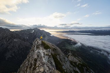 Österreich, Tirol, Gnadenwald, Hundskopf, männlicher Bergsteiger im Morgenlicht am Fels stehend - CVF00632