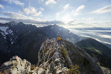 Österreich, Tirol, Gnadenwald, Hundskopf, männlicher Bergsteiger im Morgenlicht am Fels stehend - CVF00634