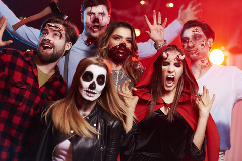 Freunde in gruseligen Kostümen haben Spaß auf einer Halloween-Party, lizenzfreies Stockfoto
