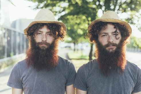 Portrait of identical male hipster twins wearing straw hats on sidewalk - CUF19801