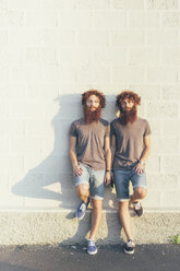 Portrait of identical adult male twins with red hair and beards against white wall - CUF19806