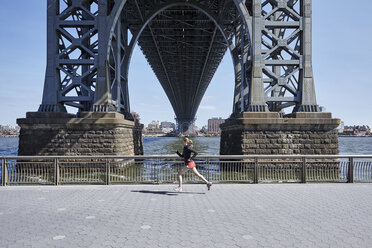 Junge Frau trainiert im Freien, läuft unter der Williamsburg Bridge, New York City, USA - CUF19880