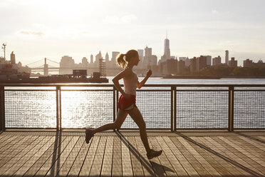 Seitenansicht einer joggenden Frau am Pier, Manhattan, New York, USA - CUF19893