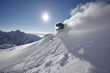 Male freestyle skier skiing down snow powdered mountainside, Zugspitze, Bayern, Germany - CUF19947