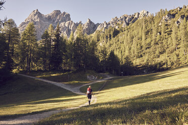 Rückansicht einer Wanderin, die in Richtung Dolomiten wandert, Sexten, Südtirol, Italien - CUF19950