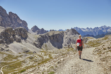 Rückansicht einer Wanderin beim Wandern in den Dolomiten, Sexten, Südtirol, Italien - CUF19953