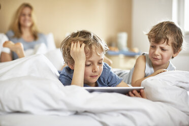 Jungen auf dem Bett der Eltern mit digitalem Tablet - CUF20034