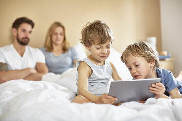 Boys on parents bed using digital tablet - CUF20035