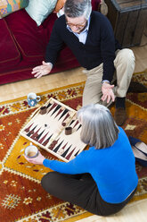 Ehepaar spielt Backgammon auf dem Boden - CUF20068