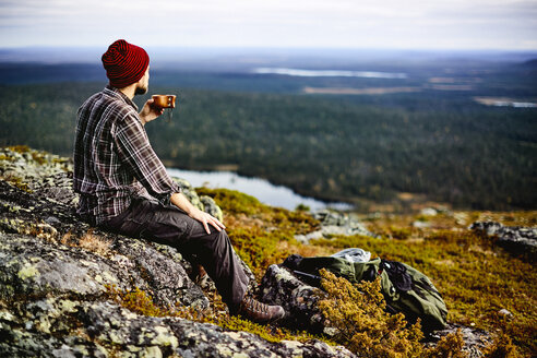 Hiker enjoying view on cliff top, Keimiotunturi, Lapland, Finland - CUF20087