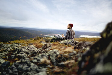 Wanderer genießt die Aussicht von der Klippe, Keimiotunturi, Lappland, Finnland - CUF20088