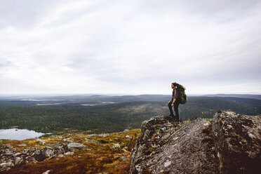 Wanderer genießt die Aussicht von der Klippe, Keimiotunturi, Lappland, Finnland - CUF20090