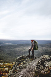 Wanderer genießt die Aussicht von der Klippe, Keimiotunturi, Lappland, Finnland - CUF20091