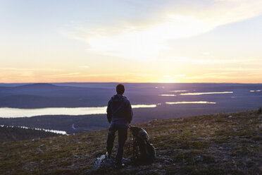 Hiker enjoying sunset at lake, Keimiotunturi, Lapland, Finland - CUF20093