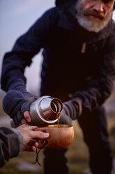 Wanderer gießt Kaffee in die Tasse eines Freundes - CUF20099