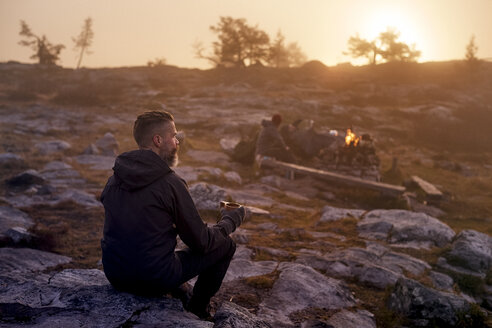 Wanderer entspannt sich bei einem Kaffee auf einem felsigen Feld, Sarkitunturi, Lappland, Finnland - CUF20101