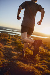 Mann beim Trailrunning auf einer Klippe bei Sonnenuntergang, Keimiotunturi, Lappland, Finnland - CUF20119