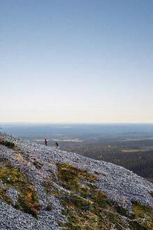 Trailrunner beim Aufstieg auf einen felsigen, steilen Hügel, Kesankitunturi, Lappland, Finnland - CUF20123