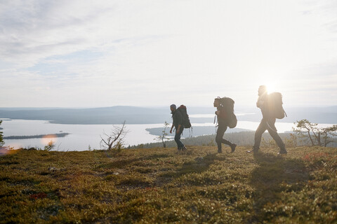 Wanderer überqueren ein Feld am See, Keimiotunturi, Lappland, Finnland, lizenzfreies Stockfoto