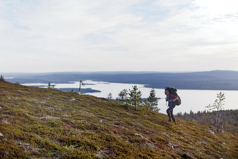 Wanderer überquert Feld am See, Keimiotunturi, Lappland, Finnland, lizenzfreies Stockfoto