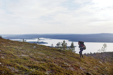 Wanderer überquert Feld am See, Keimiotunturi, Lappland, Finnland - CUF20132