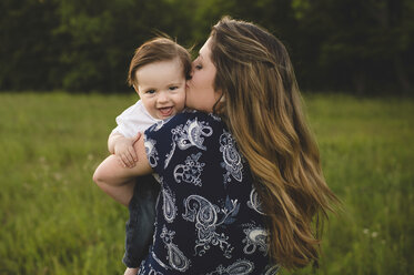 Rear view of mother holding smiling baby boy - CUF20144