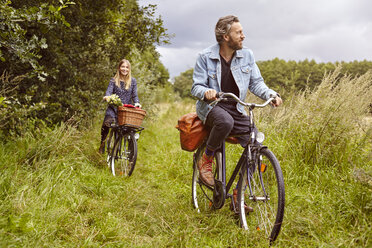 Couple cycling along rural path - CUF20167