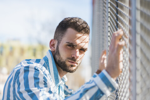 Bearded young man on a grid stock photo