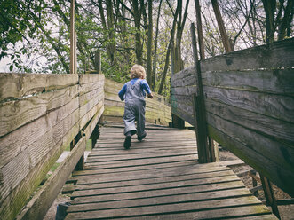 Rückenansicht eines laufenden kleinen Jungen auf dem Spielplatz - MUF01533