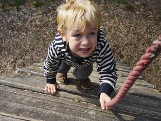 Porträt eines kleinen Jungen auf einem Klettergerüst - MUF01550