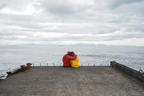 Iceland, North of Iceland, back view of couple sitting on jetty looking at view - AFVF00600