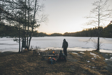 Schweden, Sodermanland, Rucksacktourist rastet an einem abgelegenen See im Winter - GUSF00923
