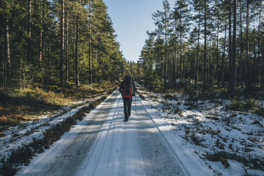 Schweden, Sodermanland, Rucksacktourist auf einem Pfad in einem abgelegenen Wald im Winter - GUSF00931
