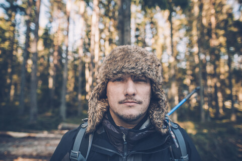 Schweden, Sodermanland, Porträt eines jungen Mannes mit Pelzmütze in abgelegener Landschaft, lizenzfreies Stockfoto
