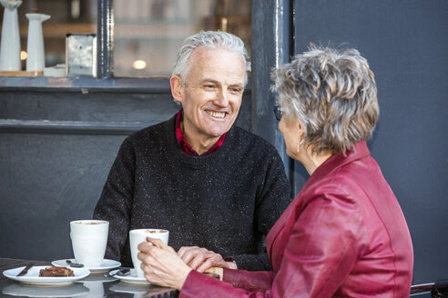 Älteres Paar in einem Straßencafé, das Kaffee trinkt und plaudert - CUF20286