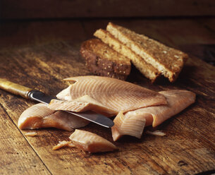 Smoked salmon with slices of wholemeal toast on wooden table - CUF20363
