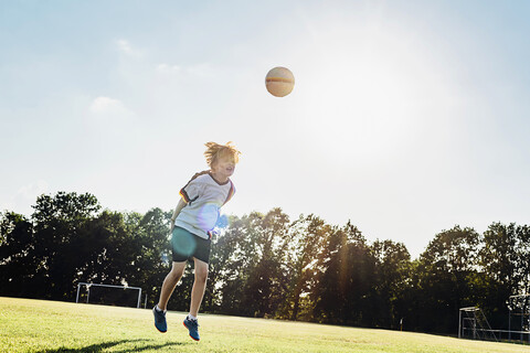 Junge mit deutschem Fußballtrikot spielt Fußball, lizenzfreies Stockfoto