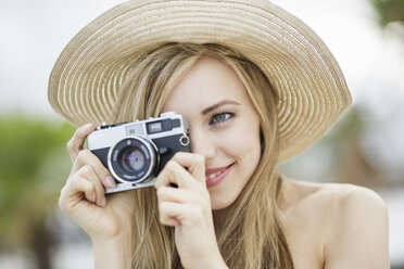 Schöne langhaarige junge Frau beim Fotografieren in der Stadt - CUF20613