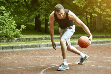 Young male basketball player running with ball on court - CUF20671