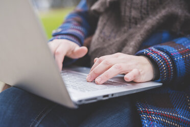 Young woman using laptop, outdoors, close-up - CUF20694