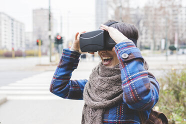 Junge Frau im Freien, die ein Virtual-Reality-Headset trägt - CUF20728