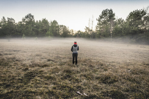 Person on misty open field, Augsburg, Bavaria, Germany - CUF20856