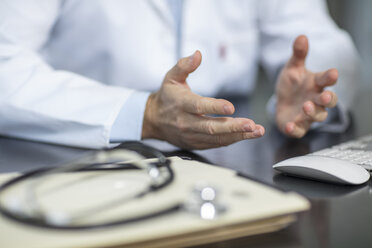 Files and stethoscope on desk in medical practice with doctor gesturing - ZEF15506