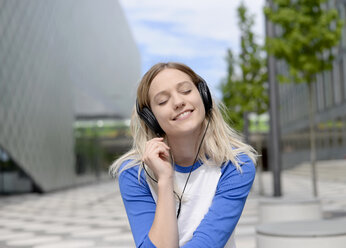 Junge blonde Frau mit Kopfhörern - BFRF01831