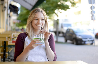 Blond young woman drinking 'Berliner Weisse' in beer garden - BFRF01837