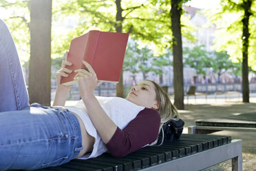 Young woman reading a book on bench - BFRF01840