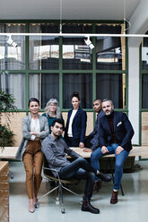 Full length portrait of confident business team at table in creative office - MASF07631